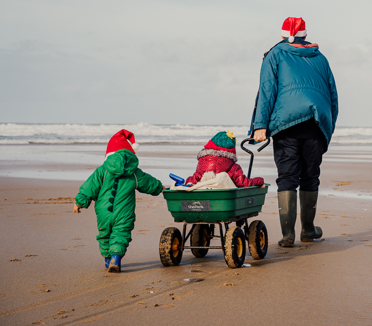 Kids and grandpa on beach christmas